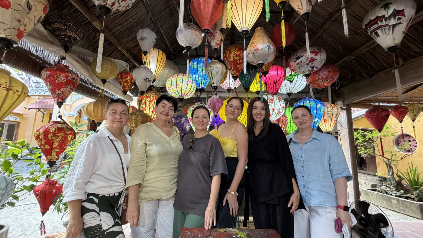 Группа туристов среди шёлковых фонарей в мастерской Хойана