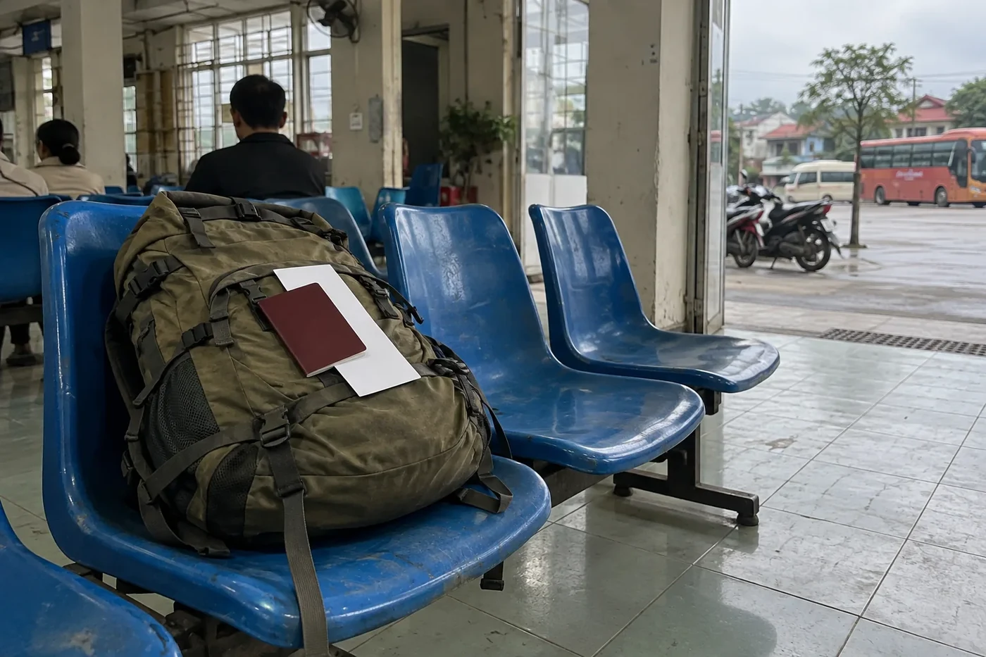 Загранпаспорт и лист бумаги лежат на рюкзаке в зале ожидания