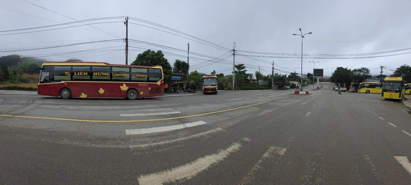 Панорама стоянки автобусов у погранперехода на фоне гор