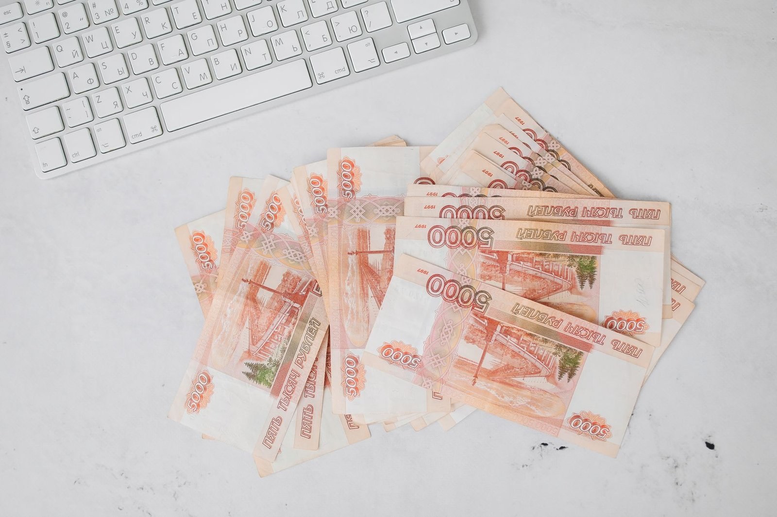 Пачка российских купюр номиналом 5000 рублей рядом с клавиатурой