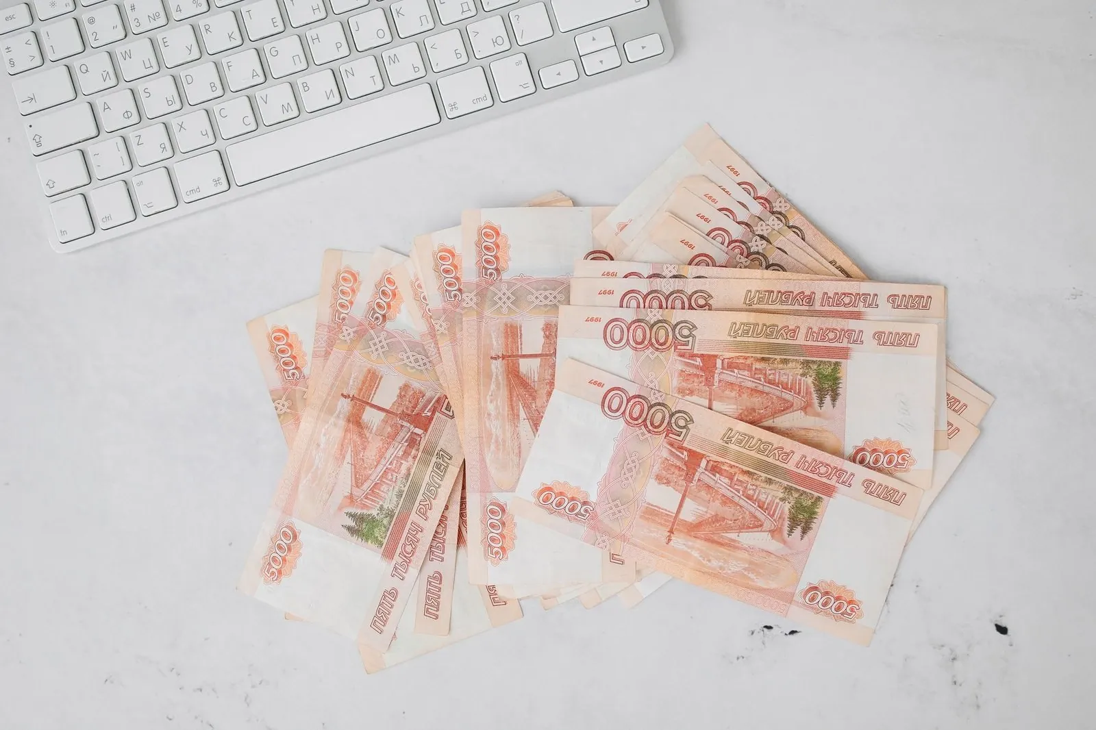 Пачка российских купюр номиналом 5000 рублей рядом с клавиатурой