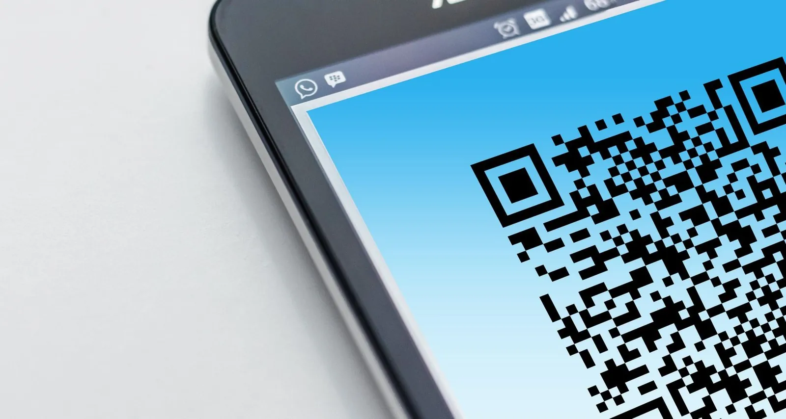 Экран смартфона с чёрно-белым QR-кодом для оплаты